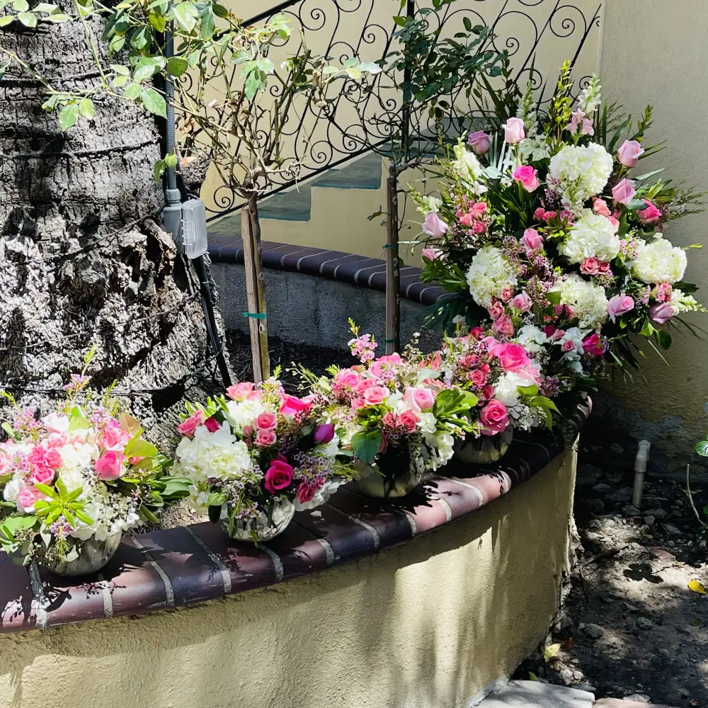 Circular fountain edge decorated with lush pink and white roses