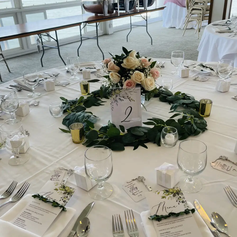 Round banquet table with wreath centerpiece and glassware
