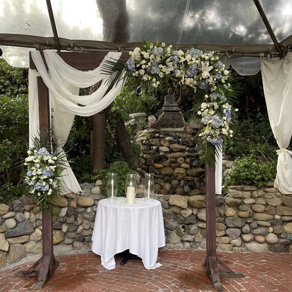 Garden wedding ceremony altar with drapery and floral swags